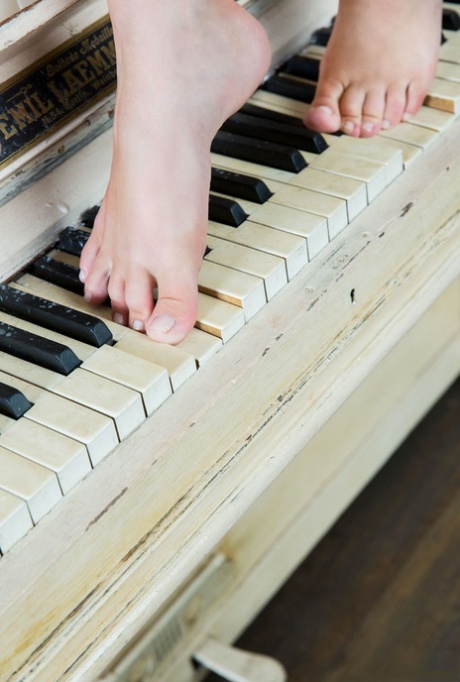 Cute teen girl Jeff Milton models in the nude on top of a piano