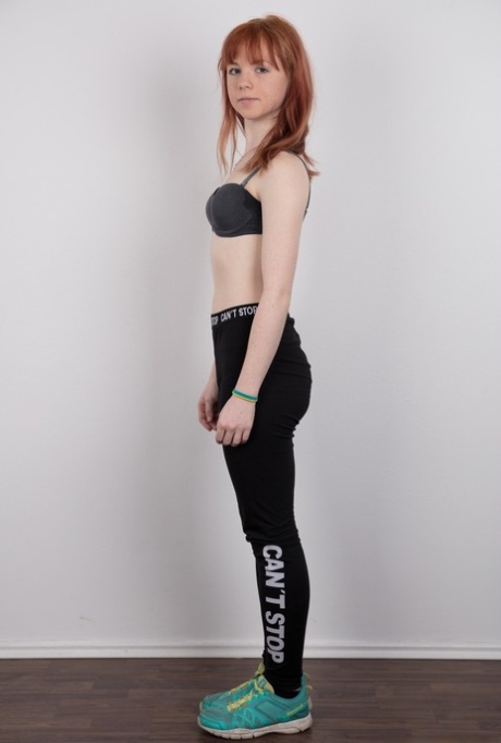 Cute redhead amateur uncovers her barely budding breasts as she gets naked