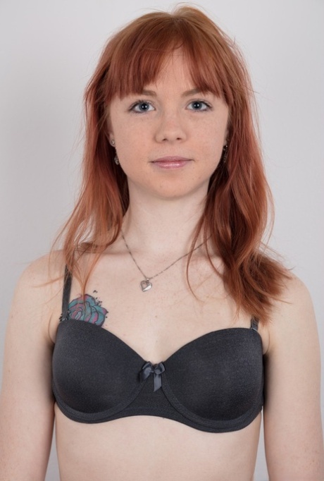 Cute redhead amateur uncovers her barely budding breasts as she gets naked