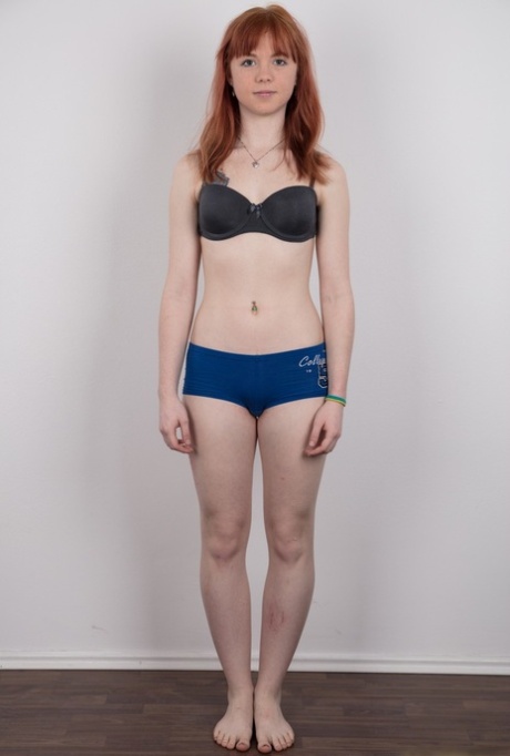 Cute redhead amateur uncovers her barely budding breasts as she gets naked
