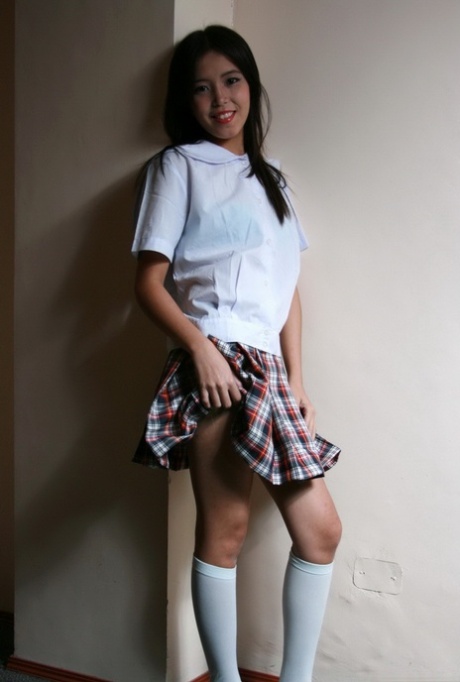 Young Asian girl takes off her school clothes for her first nude poses
