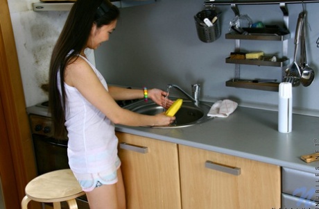Cute Asian teen spills milk on her tits while masturbating in her kitchen