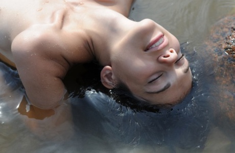 Naked amateur Tina immerses her body in shallow water near the shore