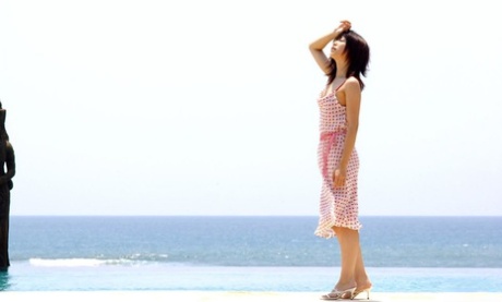 Young looking Japanese girl Saki Ninomiya gets naked with ocean behind her