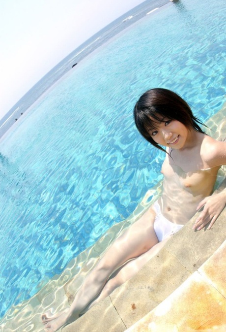 Young looking Japanese girl Saki Ninomiya gets naked with ocean behind her