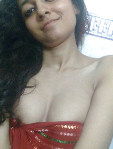 Indian solo girl holds her face firm while letting nipples free of lingerie