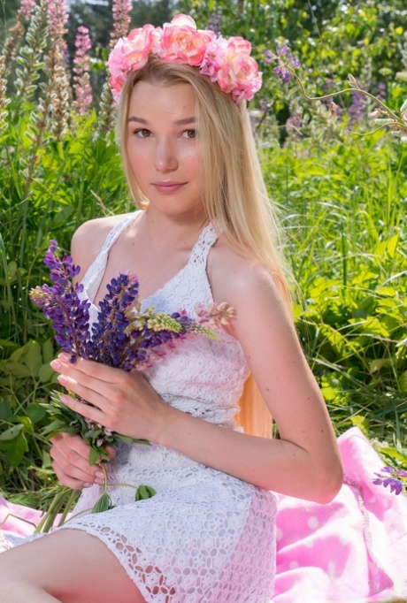 Young blonde wears a crown of flowers during her nude debut amid fireweed