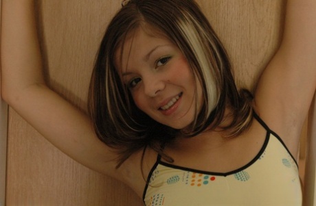 Charming young girl teases on top of her bed while wearing white panties