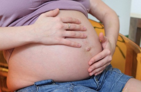 Heavily pregnant girl spills milk over her milk filled tits in the nude