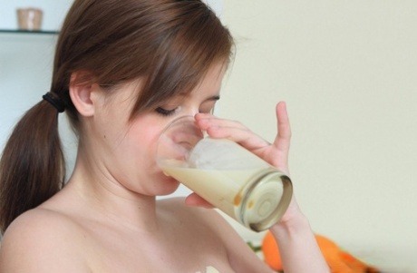 Heavily pregnant girl spills milk over her milk filled tits in the nude