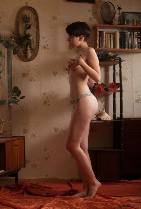 Young girl with short hair and perky tits gets naked in a confident manner