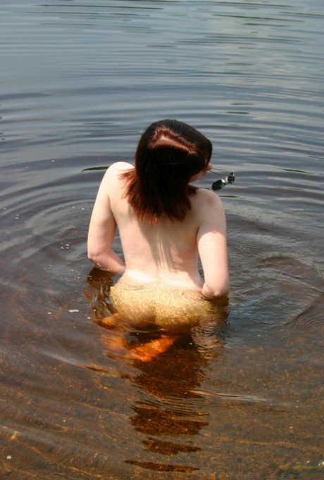 Natural redhead Barbie A exposes her boobs while naked in clear water