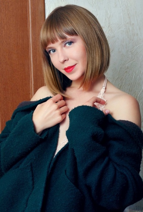 Young looking girl Dream sports red lips while getting undressed