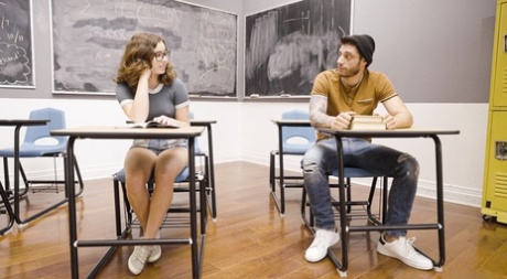 Cute young girl wears her glasses while giving a topless BJ in a classroom