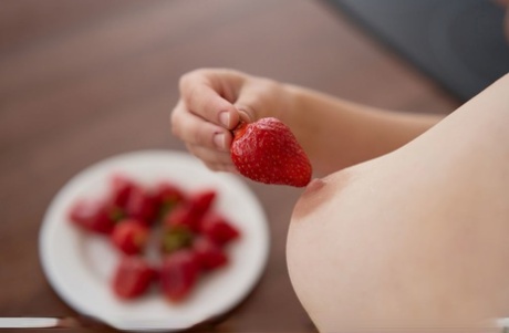 Young girl Yenn Cat gets totally naked while eating strawberries in a kitchen