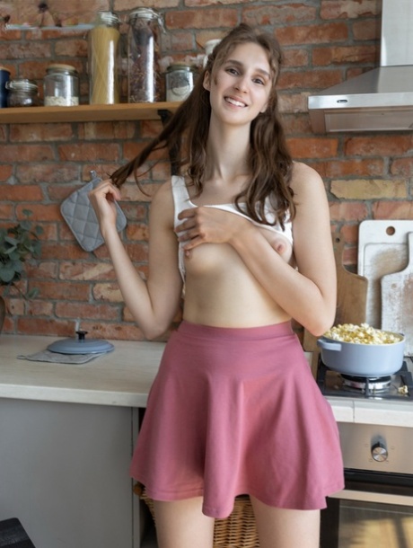 Nice teen Milly gets totally naked while cooking food in her kitchen