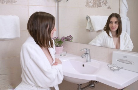 Nice teen Lillie Pie removes a white bathrobe before bathing in the buff