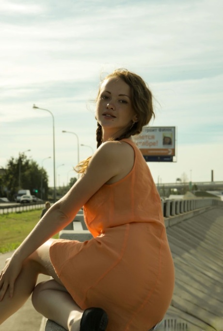 Charming teen Vega tugs on her pigtails before going nude next to the water