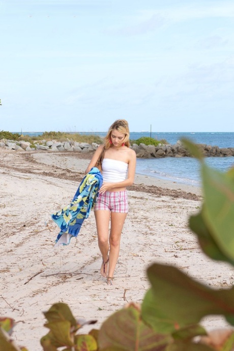 Teen girl Michelle Honeywell exposes her tight ass while sunbathing on a beach