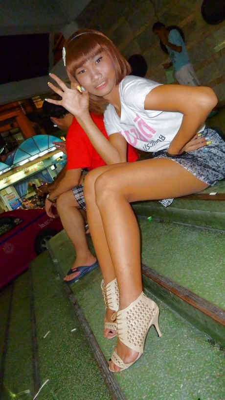 Skinny Asian tranny Jess posing outdoors in a skirt and high heels