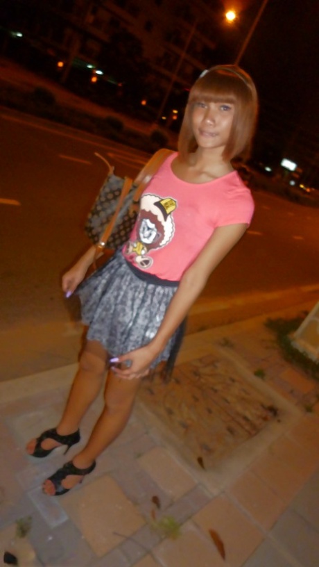 Skinny Asian tranny Jess posing outdoors in a skirt and high heels