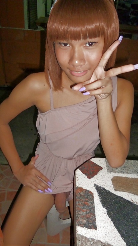 Skinny Asian tranny Jess posing outdoors in a skirt and high heels