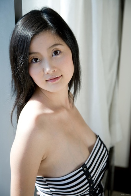 Exotic Asian girl Elva Tan reveals her natural tits as she gets naked