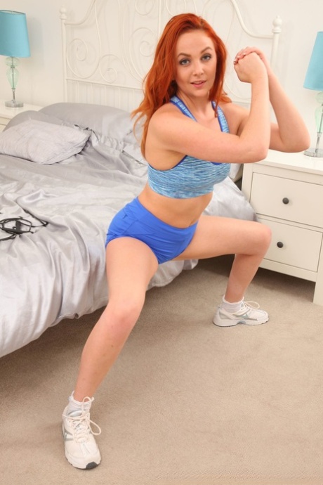 Hot redhead Kara Carter shows her nice titties and poses in blue shorts