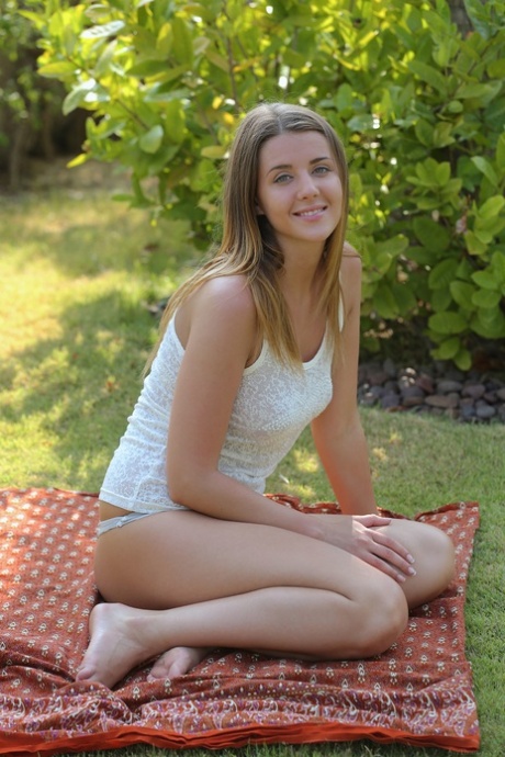 Young beauty Sybil A exposes her round butt and masturbates in the back yard