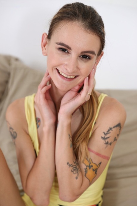 Slender tattooed teen Adelle Unicorn shows her hairy muff and toys it on a bed