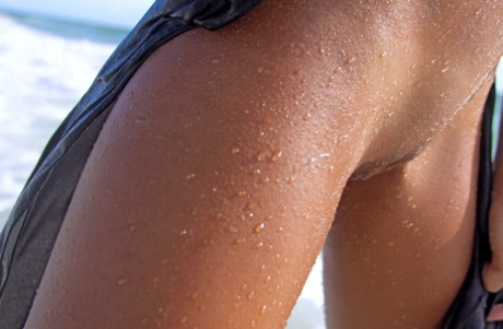 Exotic teen babe Danica A displaying her sexy tanned body & holes on the beach
