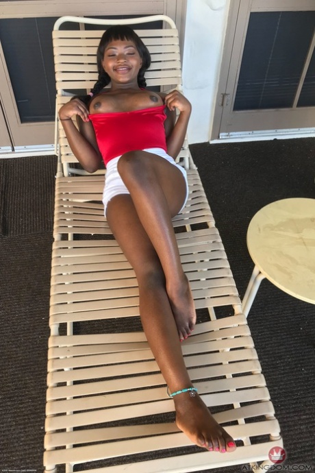 Petite ebony Noemie Bilas exposing her tits, pussy and feet in a solo
