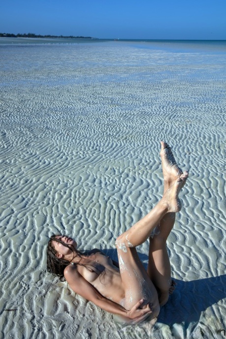 Sweet teen Irene Rouse spreads her slim legs and poses naked on the beach