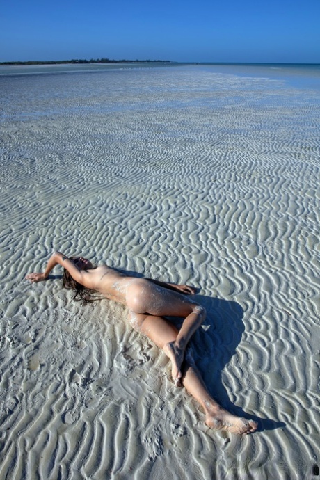 Sweet teen Irene Rouse spreads her slim legs and poses naked on the beach