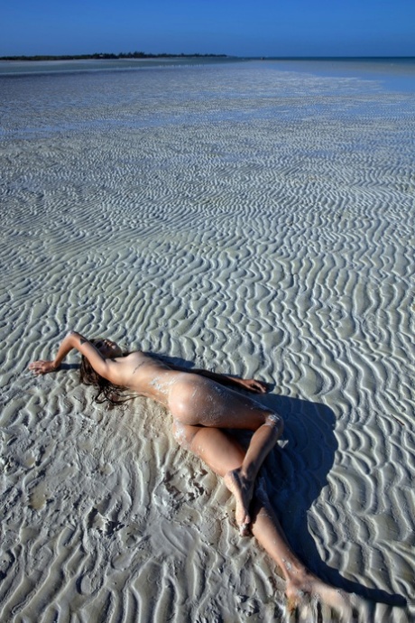 Sweet teen Irene Rouse spreads her slim legs and poses naked on the beach