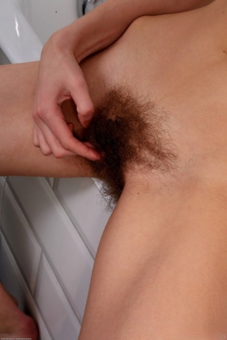 Brunette with small tits plays with her hairy beaver and masturbates in a tub